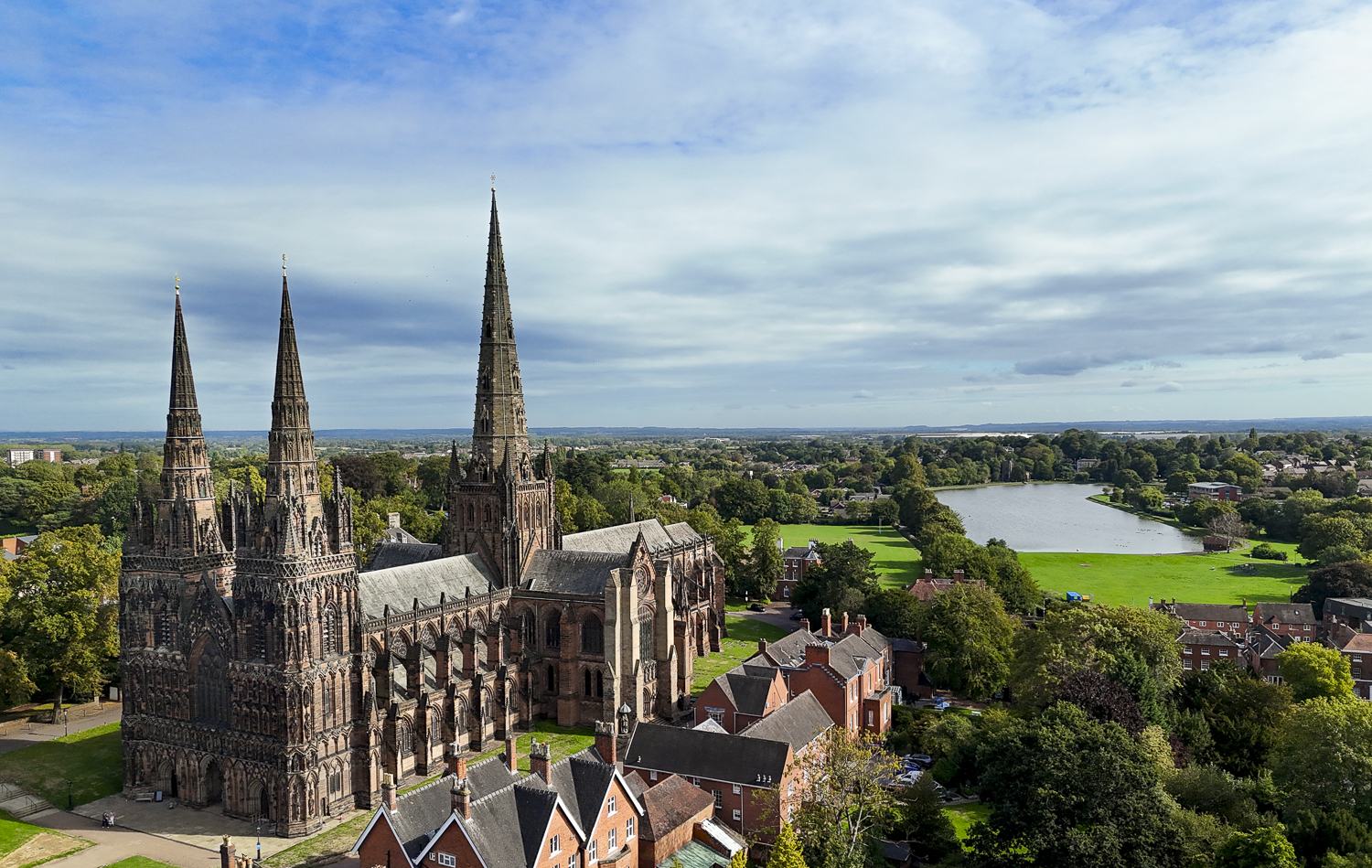 Aerial photo of Lichfield Cathedral's three spires with Stowe Pool beyond
