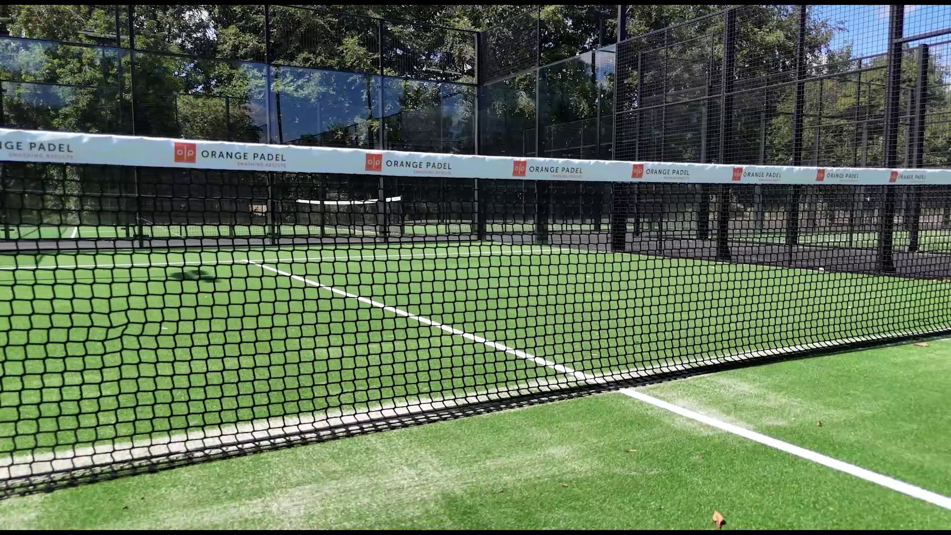 Low drone shot along a padel court net