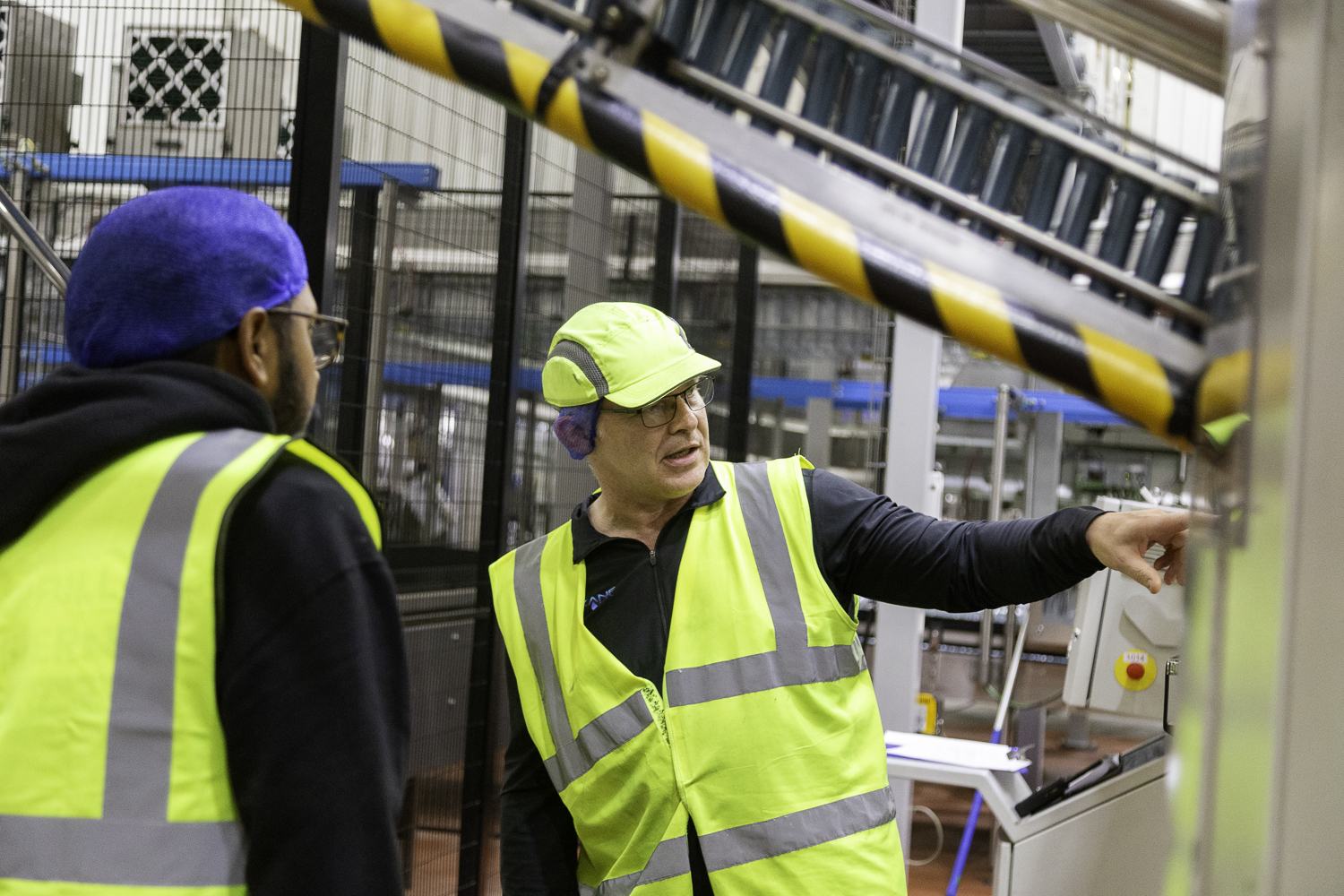 Production manager briefing a colleague on the factory floor