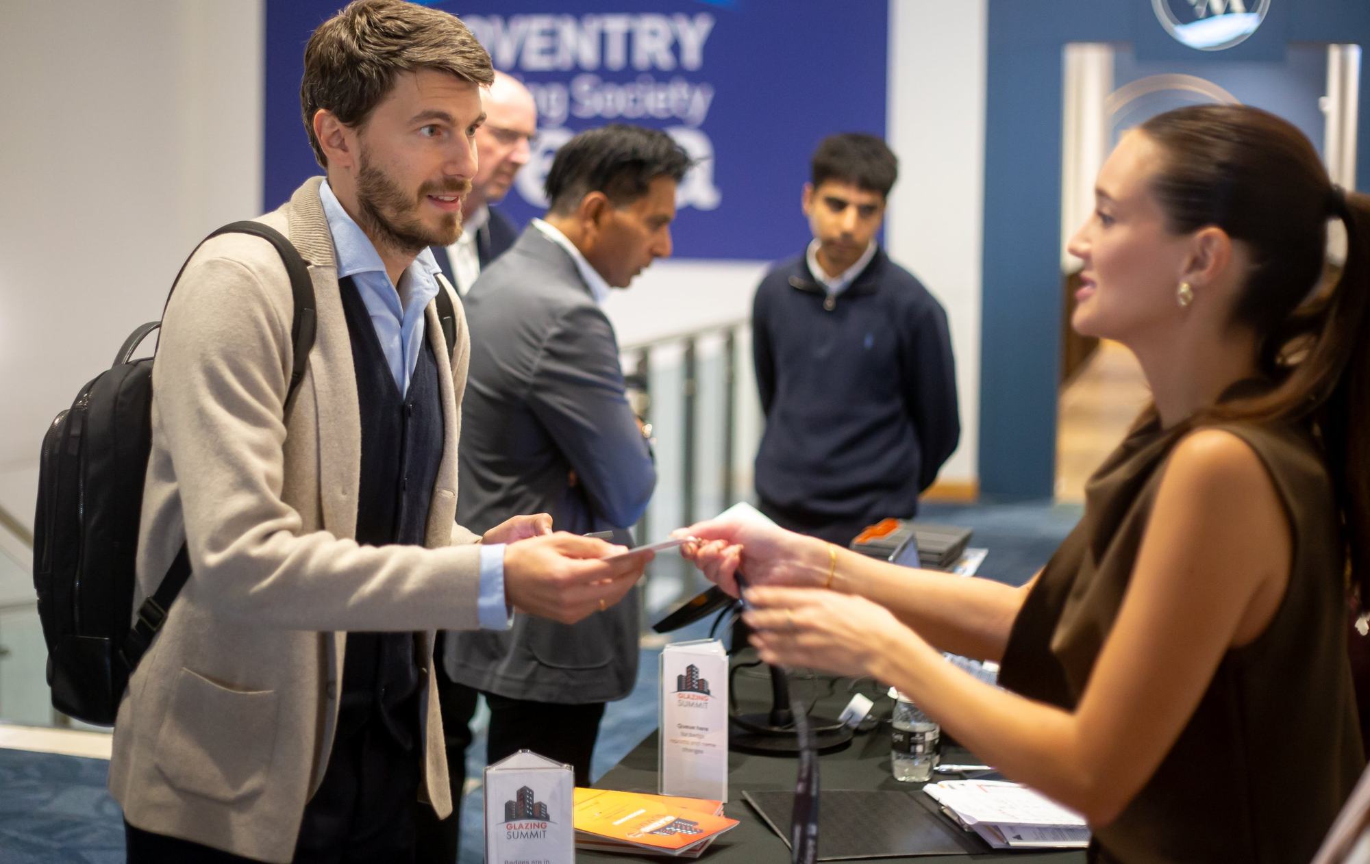Delegate collecting a badge at Glazing Summit registration