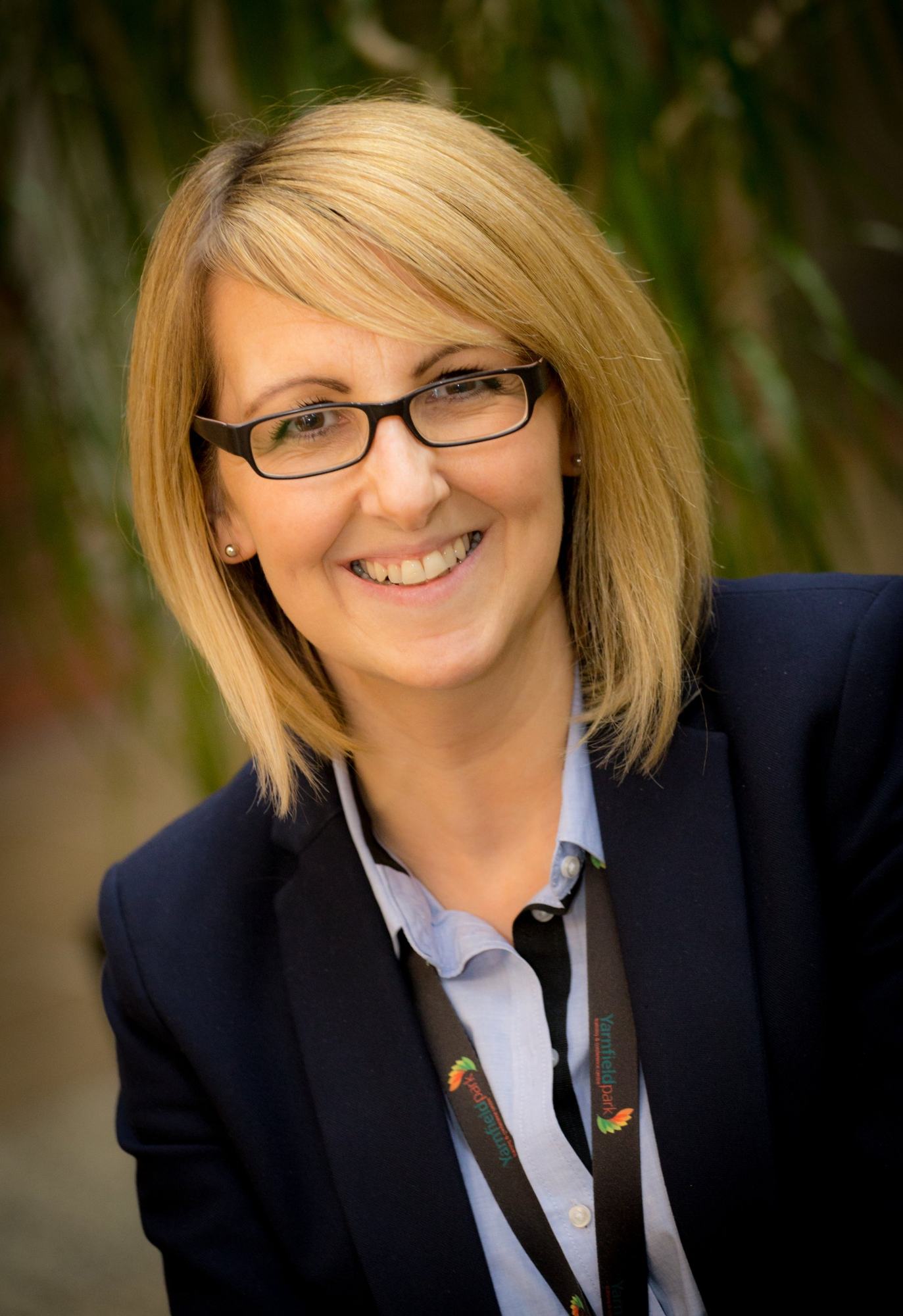 Business headshot on location with a natural green backdrop