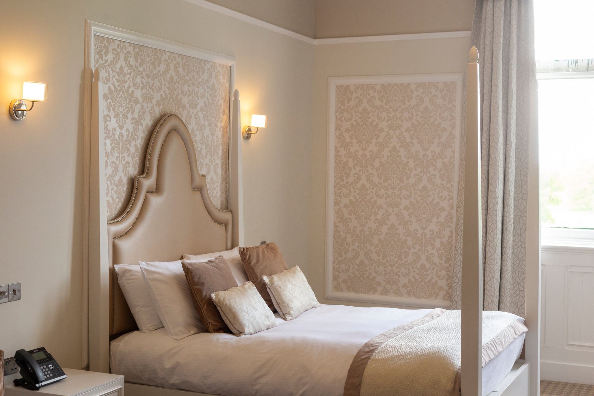Four-poster bed and damask panels in a hotel suite