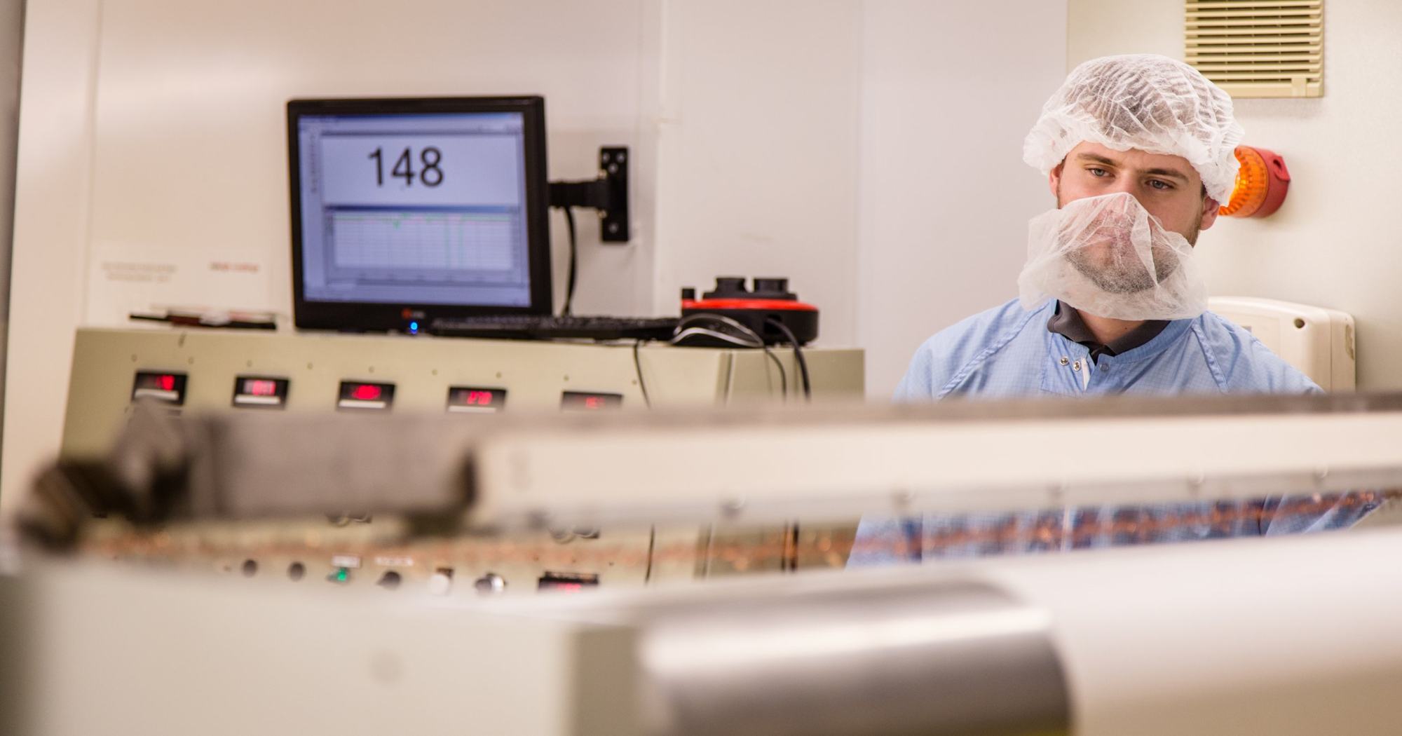 Technician in protective wear in a cleanroom