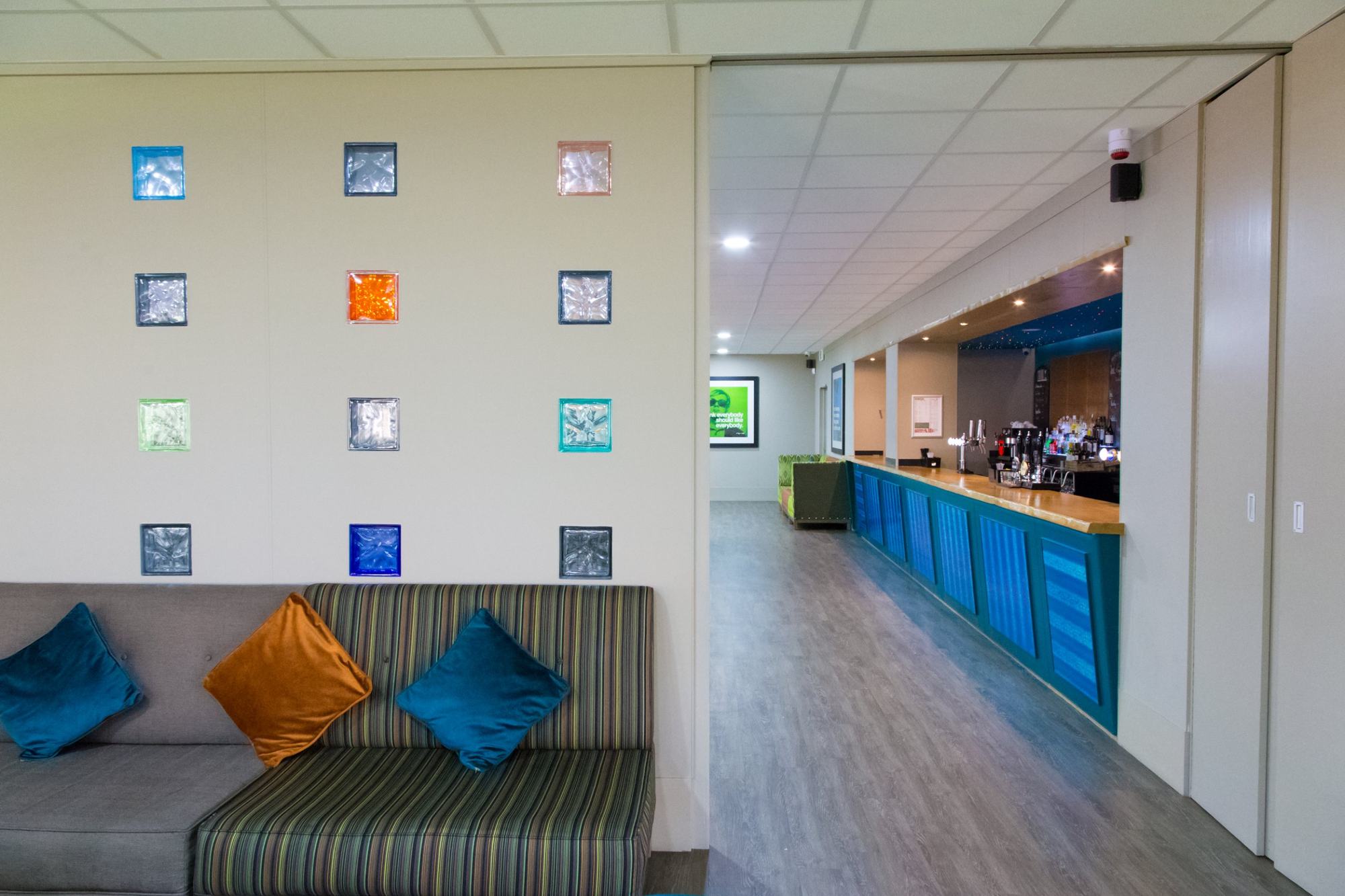 Bar and lounge with coloured glass blocks and a long blue bar