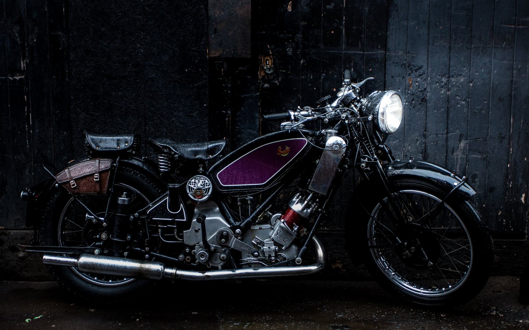 Vintage motorbike against dark weathered timber