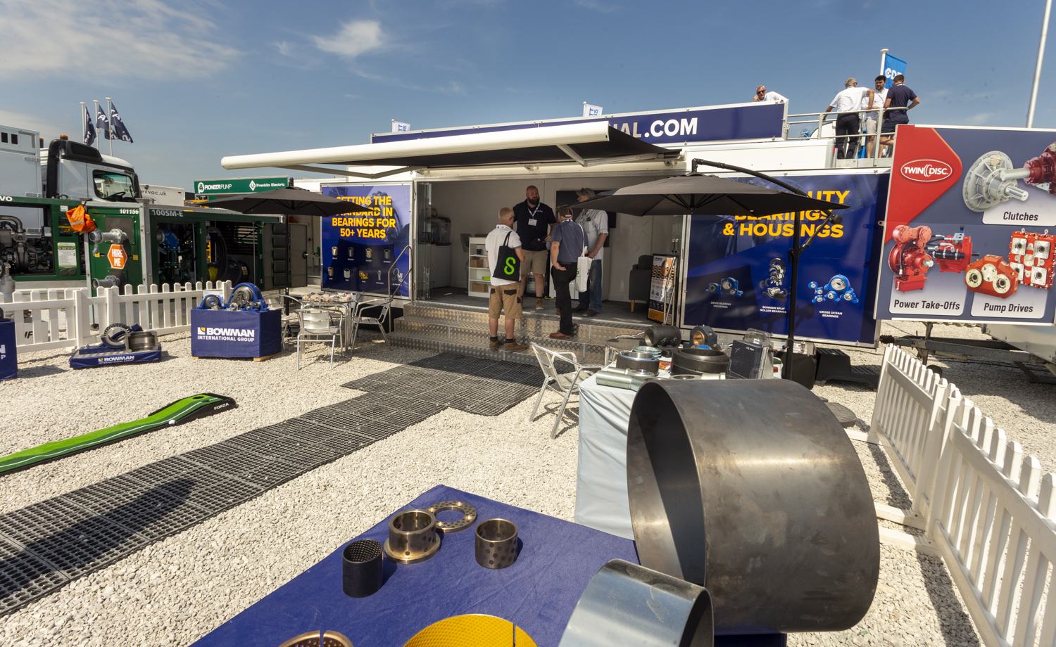Visitors talking with exhibitors at an outdoor trade show stand